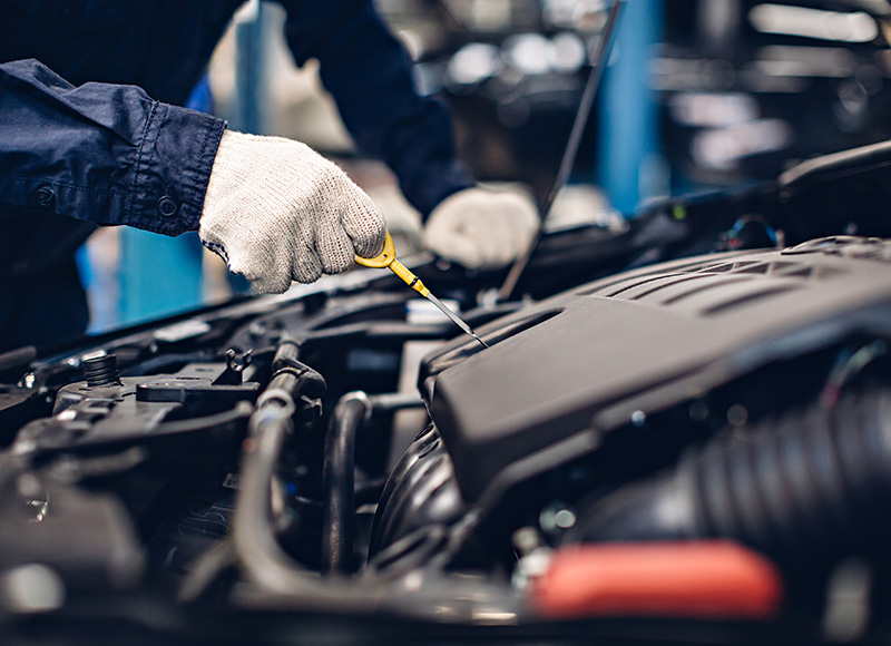 Technician checking a Buick SUV engine during routine maintenance service.