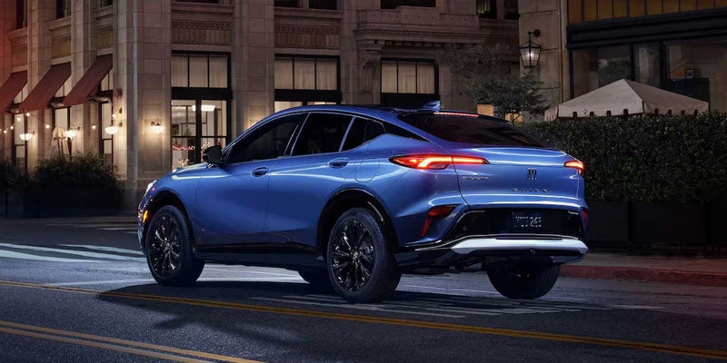 Blue SUV driving at night with illuminated taillights, rear view